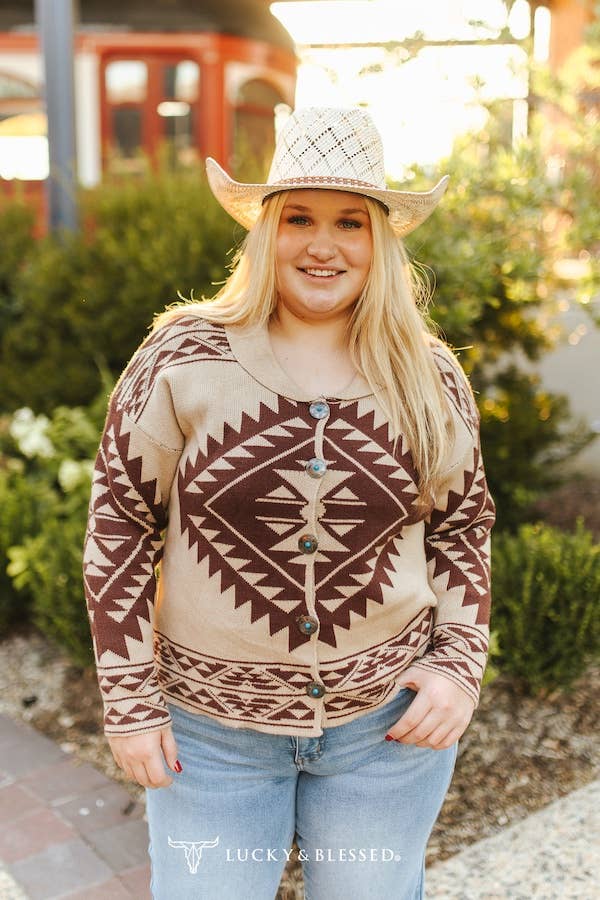 Woman wearing a patterned sweater and cowboy hat with a blurred background