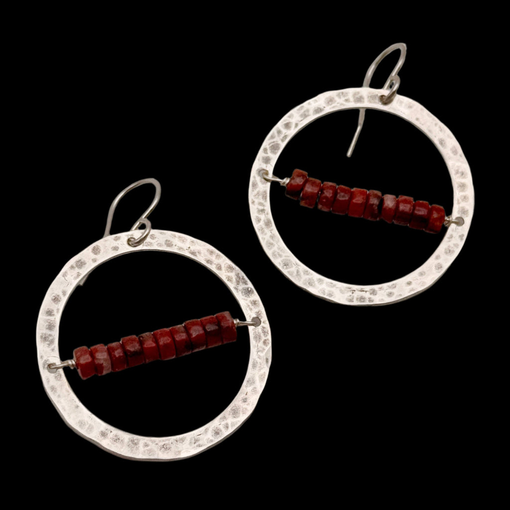 Handmade Desert Ember Hoops featuring red jasper stones wrapped inside a silver textured hoop, hanging from hypoallergenic sterling silver ear wires.