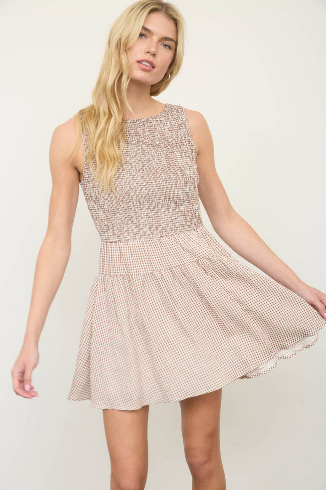 Smocked gingham mini dress with sleeveless design and A-line silhouette
