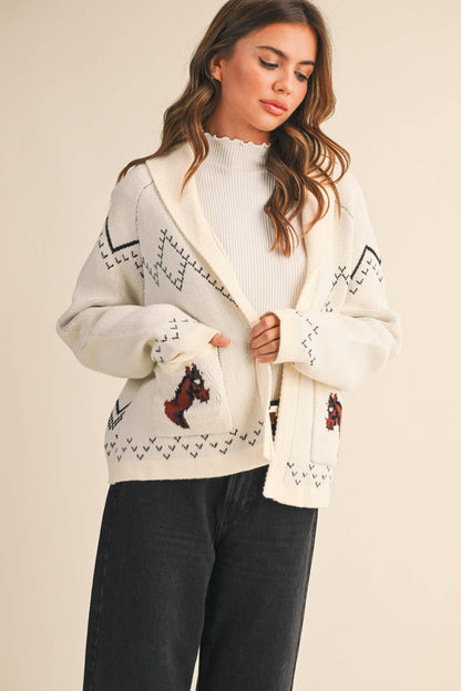 Woman wearing a patterned cardigan with a neutral background