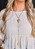 Gold Dust Trail Lariat necklace featuring a gold chain with a silver concho detail and a 9-inch cascading tail, styled with Western elegance