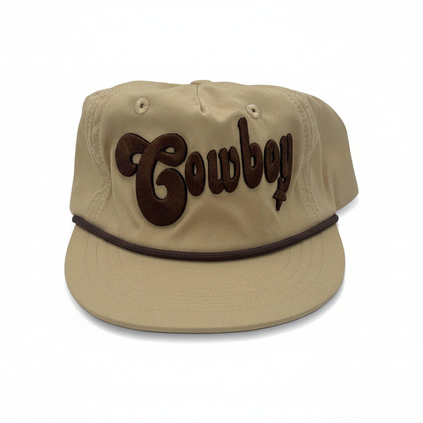 Infant cowboy cap in khaki with brown embroidered “Cowboy” lettering and rope detail across the brim, western-style baby hat