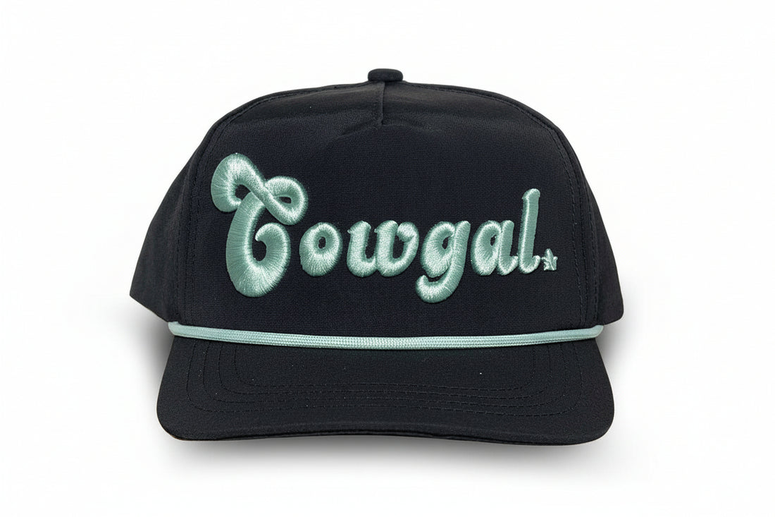 Infant cowgal cap in black with mint embroidered “Cowgal” lettering and rope detail across the brim, western-style baby hat