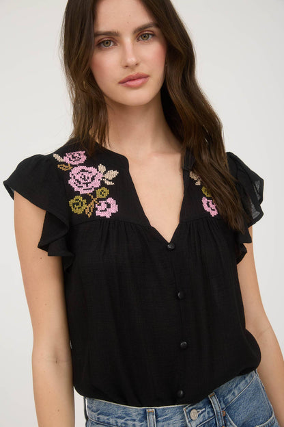 Black blouse with floral embroidery, ruffle sleeves, and relaxed fit in a lightweight woven fabric
