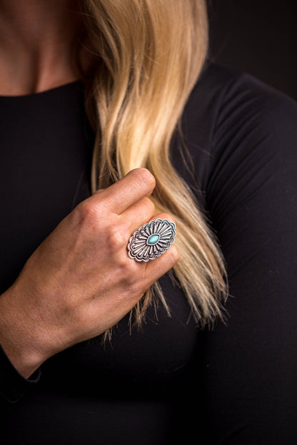 Navajo Bloom Ring featuring an adjustable oval concho design with intricate silver detailing and a turquoise accent, inspired by Southwestern heritage
