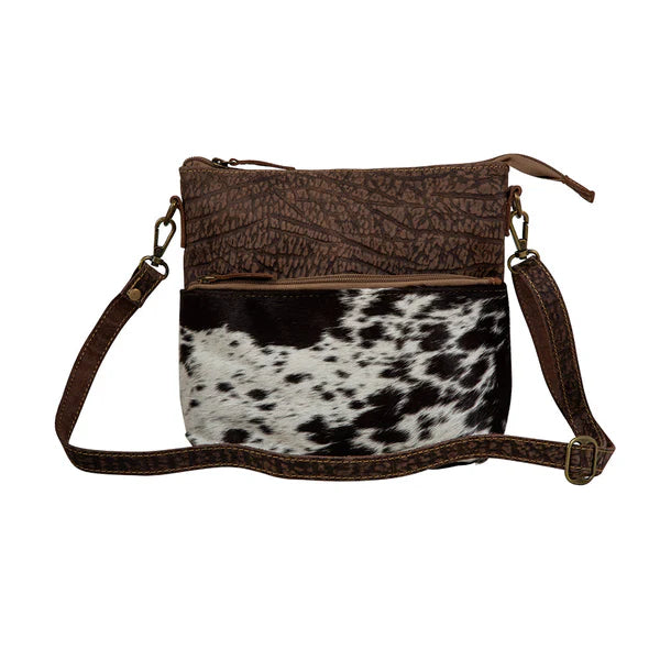 Point Rock Crossbody Bag – Aged bourbon chocolate-stamped leather and hair-on hide crossbody with zip-top closure, zippered pockets, and a matching leather shoulder strap.