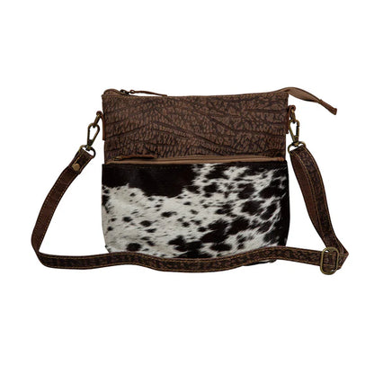 Point Rock Crossbody Bag – Aged bourbon chocolate-stamped leather and hair-on hide crossbody with zip-top closure, zippered pockets, and a matching leather shoulder strap.