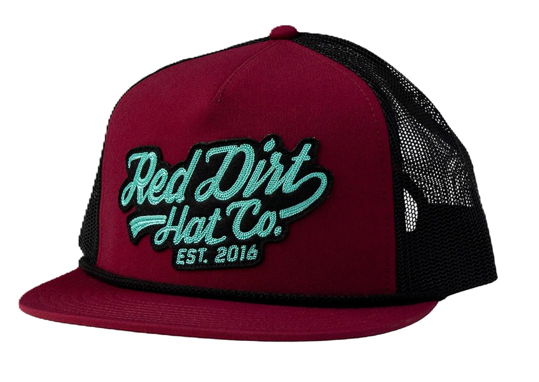 Red Dirt Hat Co. Off The Vine Hat featuring a burgundy front panel, black mesh back, teal 3D embroidered logo patch, rope detail, and a flat bill.