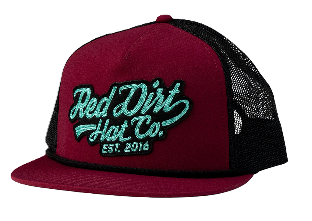 Red Dirt Hat Co. Off The Vine Hat featuring a burgundy front panel, black mesh back, teal 3D embroidered logo patch, rope detail, and a flat bill.