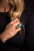 Sage & Sky Ring featuring a 2-inch adjustable silver setting with a turquoise teardrop and green oval stone, inspired by Southwestern landscapes.