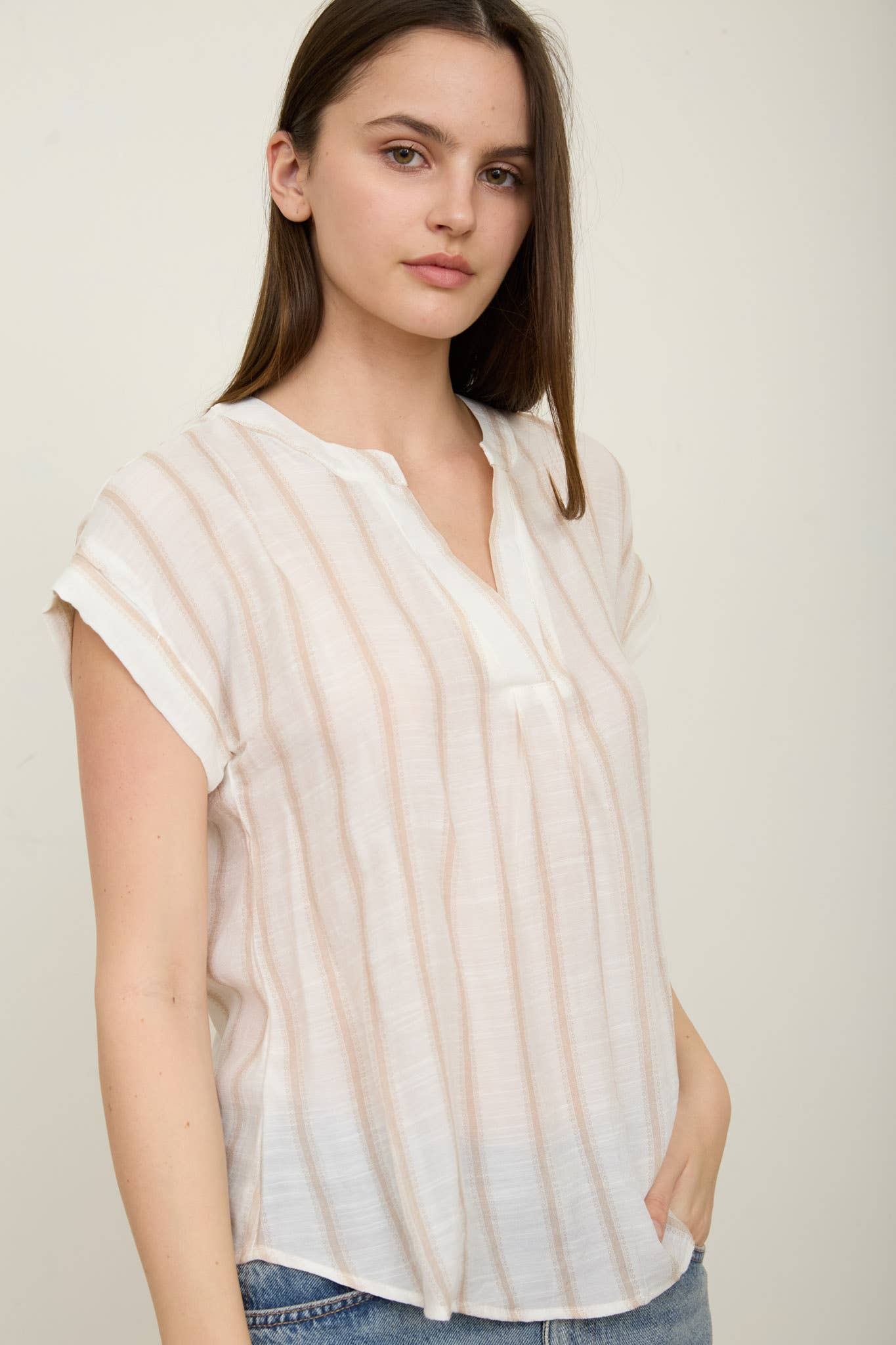Lightweight striped blouse with split neckline, short cuffed sleeves, and soft neutral tones