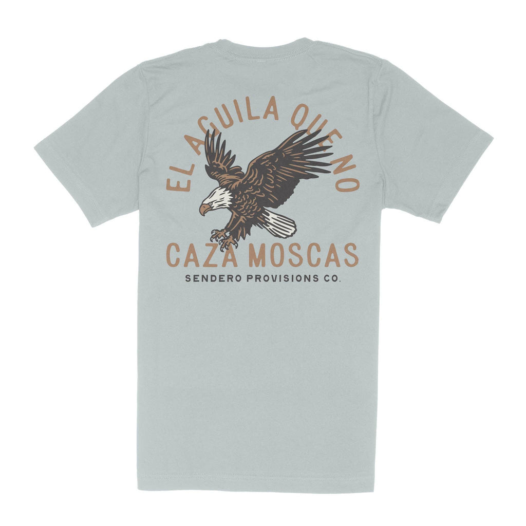Light sage green t-shirt featuring a Sendero Provisions Co. graphic on the back with a soaring eagle and the Spanish phrase "El Águila Que No Caza Moscas." Classic fit with a soft, comfortable feel