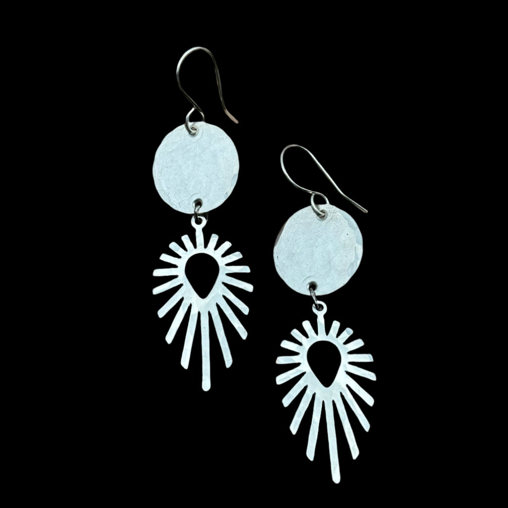 Handmade Solstice Trail Earrings featuring silver pendants with a circular accent, hanging from hypoallergenic sterling silver ear wires.