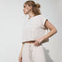 Cropped pinstripe top with short cuffed sleeves, chest pocket, and back button detail in a lightweight linen blend